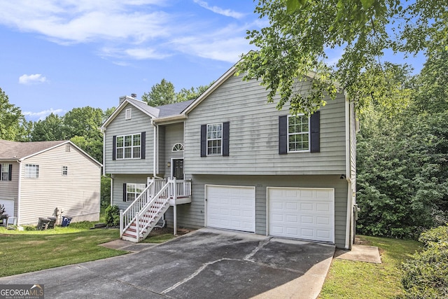 bi-level home with a garage and a front lawn