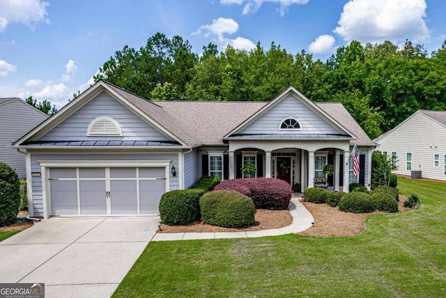 view of front of home featuring a porch, a garage, and a front lawn