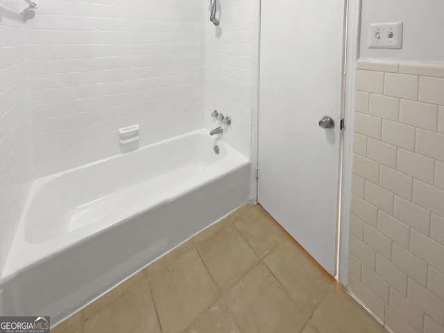 bathroom featuring tiled shower / bath, tile patterned floors, and tile walls