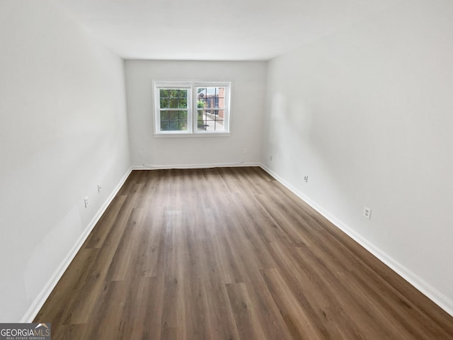 empty room with dark hardwood / wood-style flooring