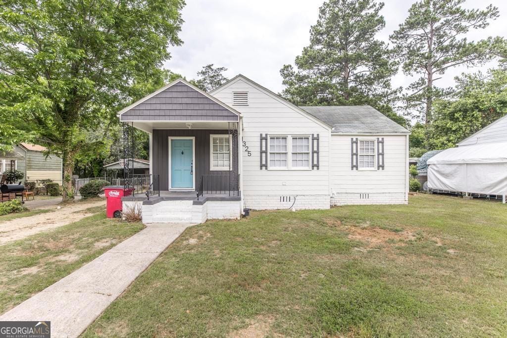 bungalow-style home with a front yard