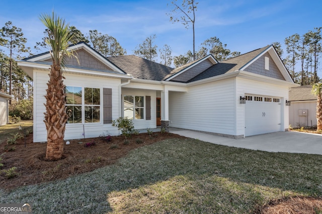 view of front of property featuring a front yard, roof with shingles, driveway, and an attached garage