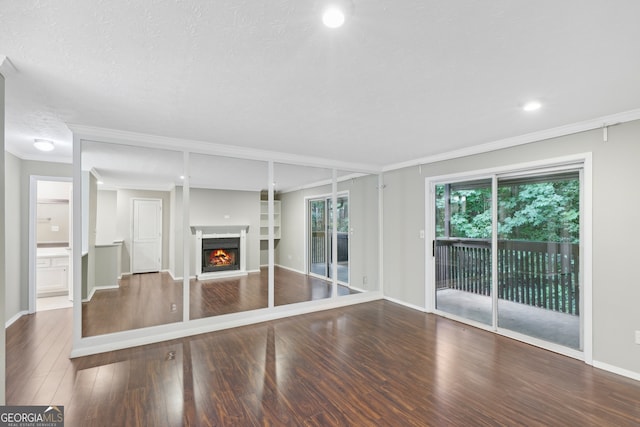 unfurnished living room with ornamental molding, a textured ceiling, and wood-type flooring