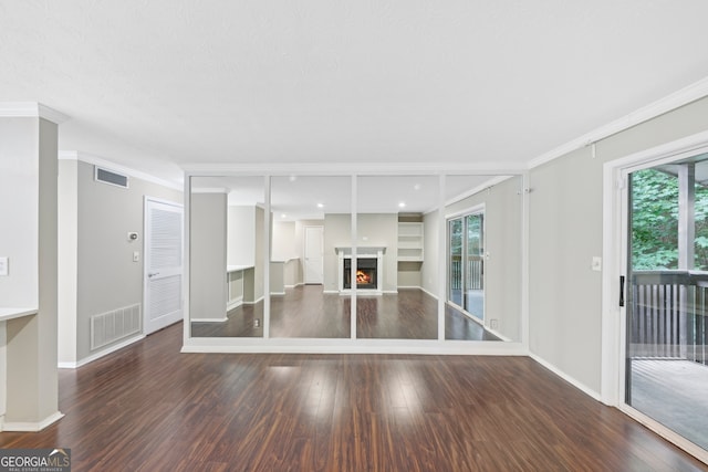 unfurnished living room with a wealth of natural light, dark hardwood / wood-style flooring, and crown molding