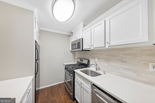 kitchen with crown molding, appliances with stainless steel finishes, white cabinets, sink, and dark hardwood / wood-style flooring