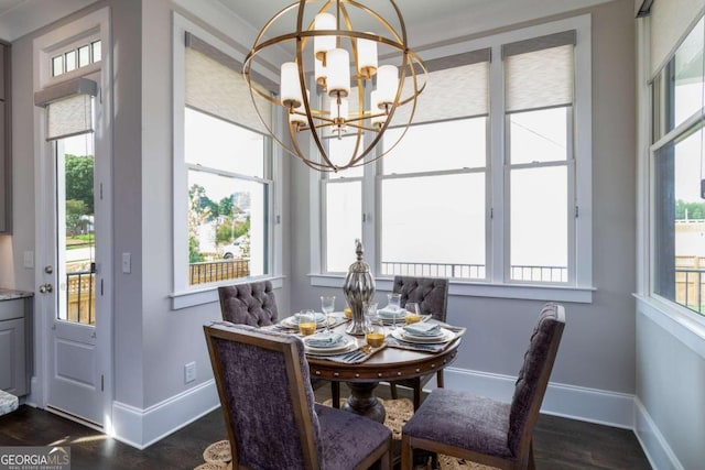 dining room with a healthy amount of sunlight, dark hardwood / wood-style flooring, ornamental molding, and a chandelier