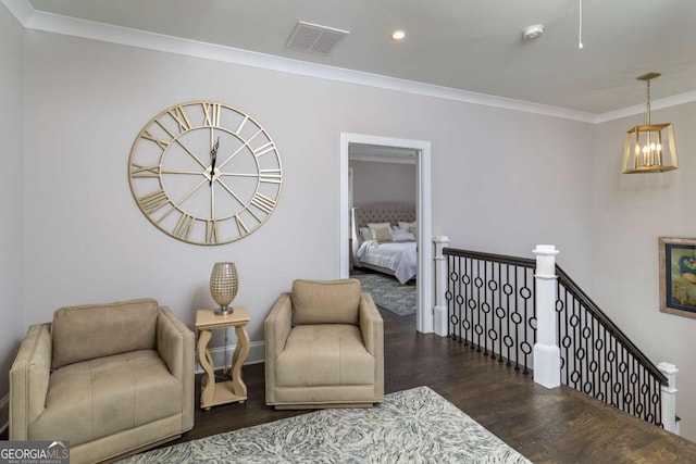 sitting room with dark hardwood / wood-style flooring, ornamental molding, and an inviting chandelier