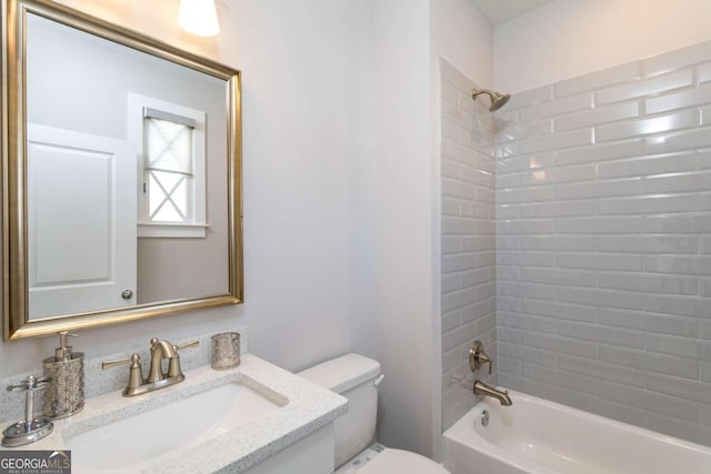 full bathroom with vanity, tiled shower / bath combo, and toilet