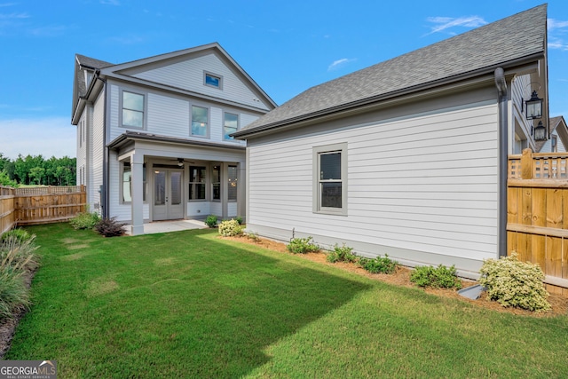 rear view of property with a yard, a patio area, and ceiling fan