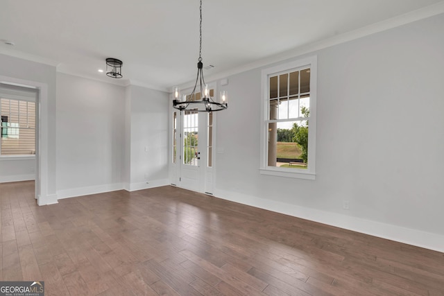 unfurnished dining area with crown molding, a chandelier, and dark wood-type flooring