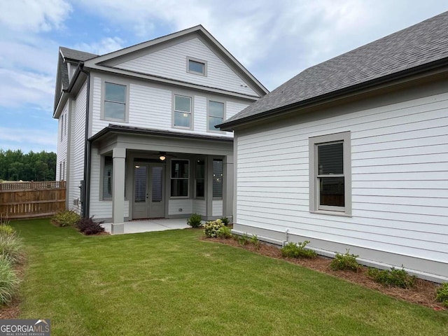 rear view of property featuring a lawn and french doors