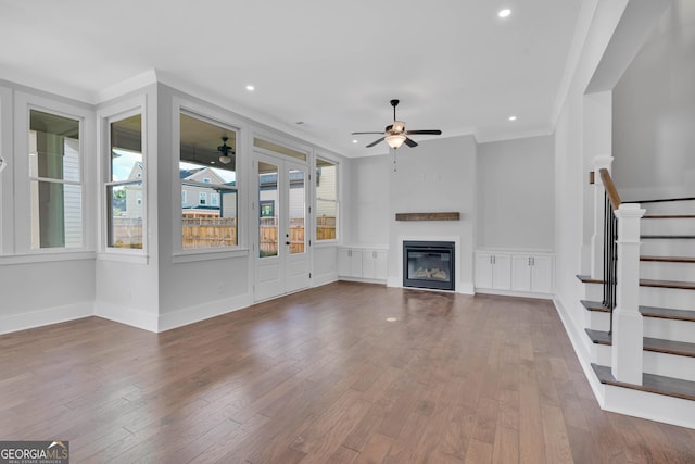 unfurnished living room with hardwood / wood-style flooring, ceiling fan, and ornamental molding