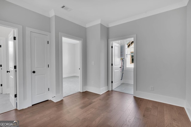 empty room featuring crown molding and dark hardwood / wood-style flooring