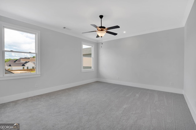 carpeted empty room with ceiling fan and ornamental molding