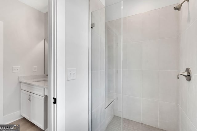 bathroom with a shower with door and vanity