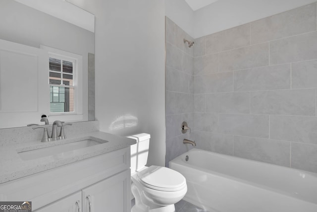 full bathroom featuring vanity, tiled shower / bath, and toilet