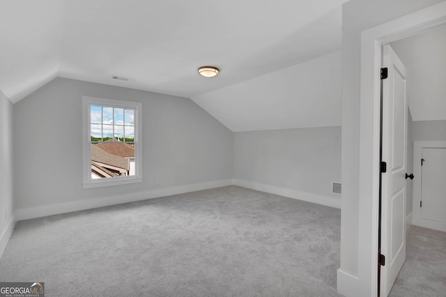 additional living space with vaulted ceiling and light carpet