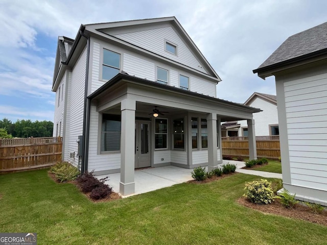 back of property with a lawn, a patio, and ceiling fan