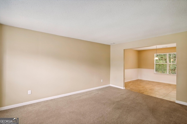 carpeted empty room with a textured ceiling