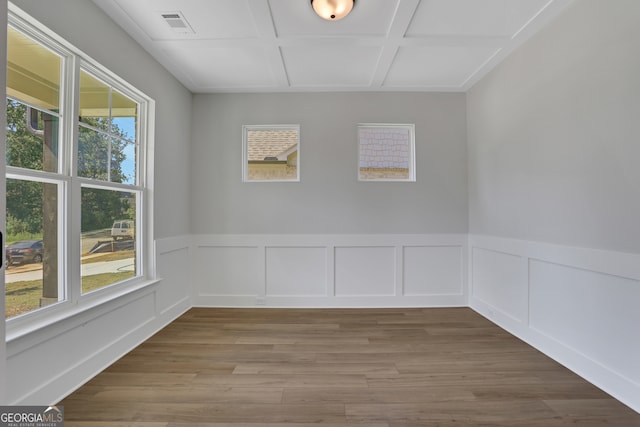 unfurnished room with wood-type flooring, coffered ceiling, and a wealth of natural light