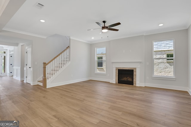 unfurnished living room with a wealth of natural light, light hardwood / wood-style floors, ceiling fan, and a tile fireplace