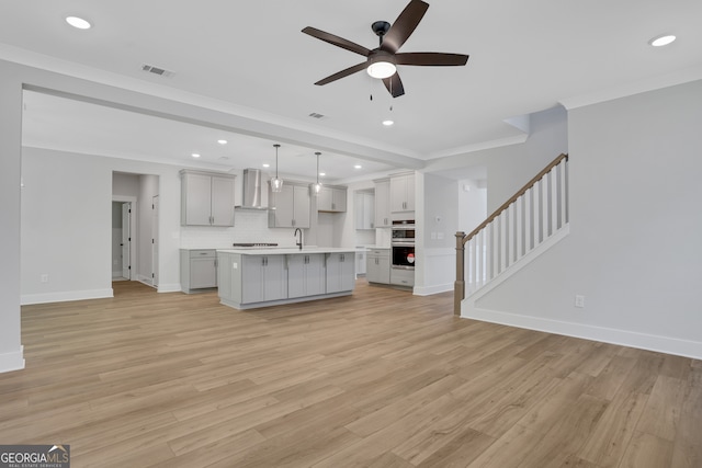 unfurnished living room featuring light hardwood / wood-style flooring, ceiling fan, ornamental molding, and sink