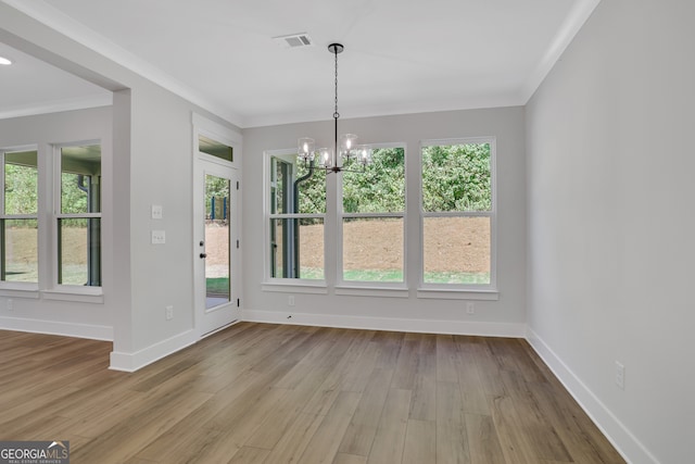 unfurnished dining area with light hardwood / wood-style flooring, a wealth of natural light, and a chandelier