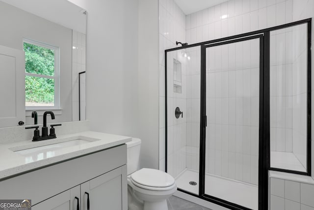 bathroom with tile patterned flooring, vanity, toilet, and an enclosed shower