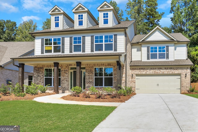 craftsman inspired home with a front yard, a garage, and covered porch