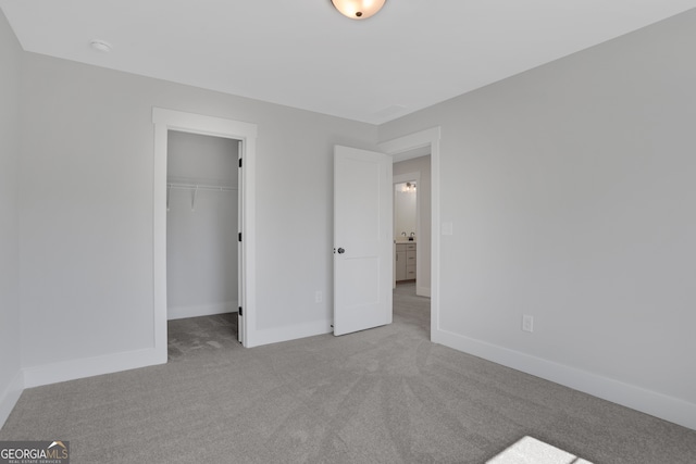 unfurnished bedroom featuring light colored carpet, a closet, and a walk in closet