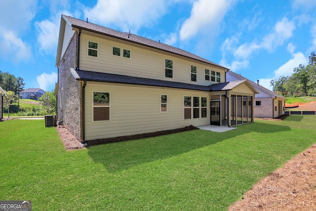 rear view of property with cooling unit, a sunroom, a lawn, and a patio