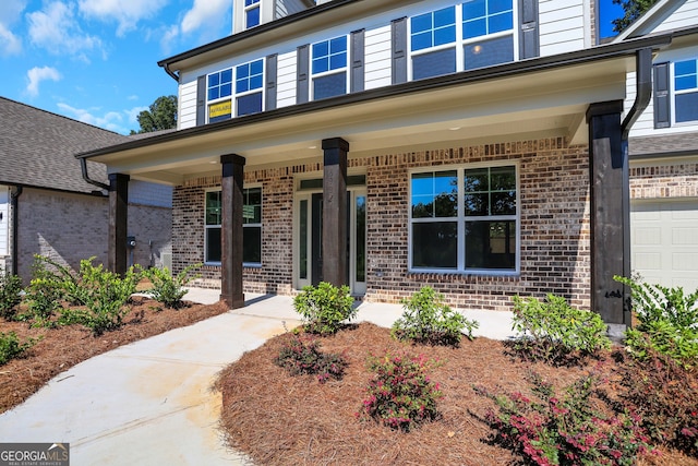 doorway to property with a garage and covered porch