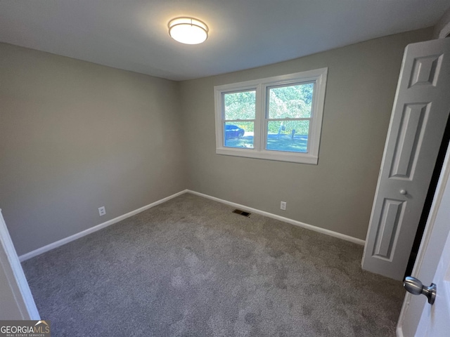 empty room featuring dark colored carpet