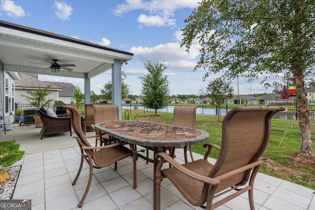 view of patio with a water view and ceiling fan