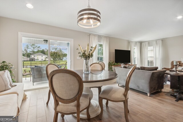 dining area with light hardwood / wood-style flooring and a chandelier