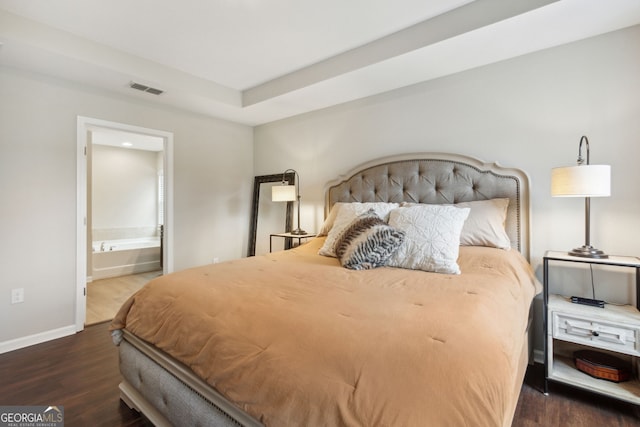 bedroom with ensuite bathroom and dark hardwood / wood-style floors