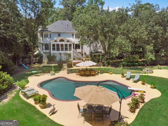 view of swimming pool with a diving board, a patio area, and a yard