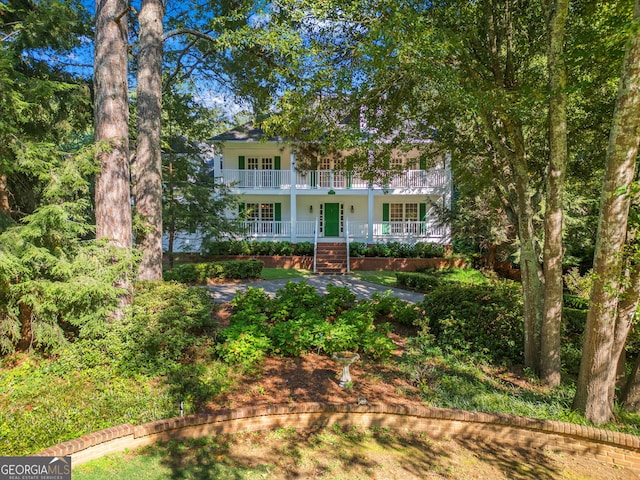 rear view of property featuring a balcony and a porch