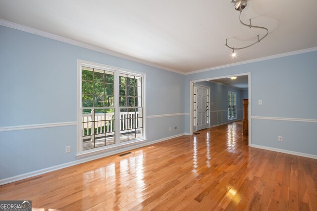 unfurnished room featuring crown molding and hardwood / wood-style floors