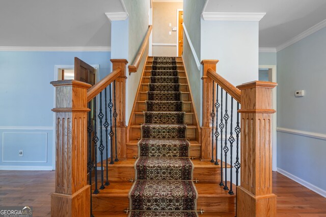 stairway featuring crown molding and wood-type flooring