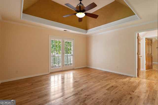 unfurnished room with ceiling fan, a raised ceiling, light hardwood / wood-style flooring, and ornamental molding