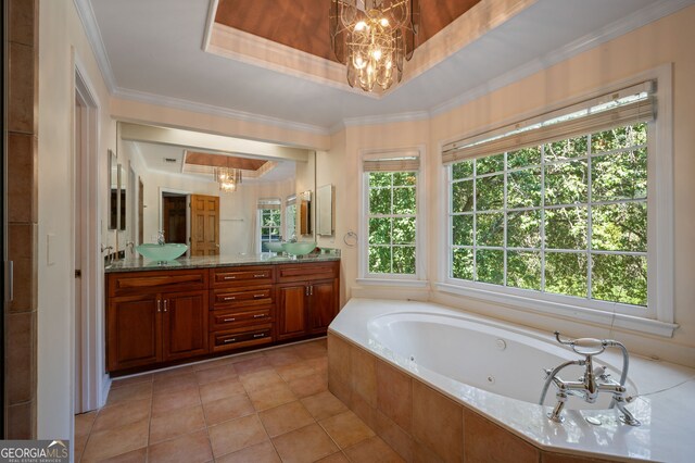 bathroom with a wealth of natural light, tiled tub, a raised ceiling, and vanity