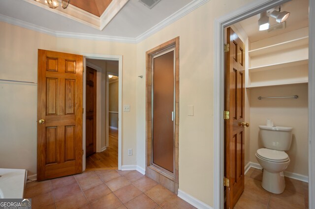 bathroom featuring crown molding, toilet, walk in shower, and tile patterned floors