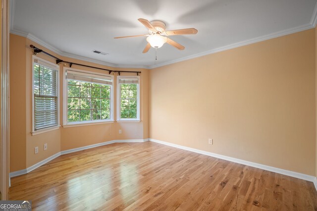 spare room featuring light wood-type flooring, crown molding, ceiling fan, and a healthy amount of sunlight