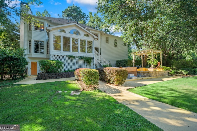 view of front facade featuring a pergola and a front yard