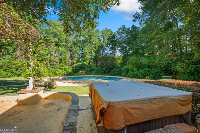 view of swimming pool featuring a hot tub