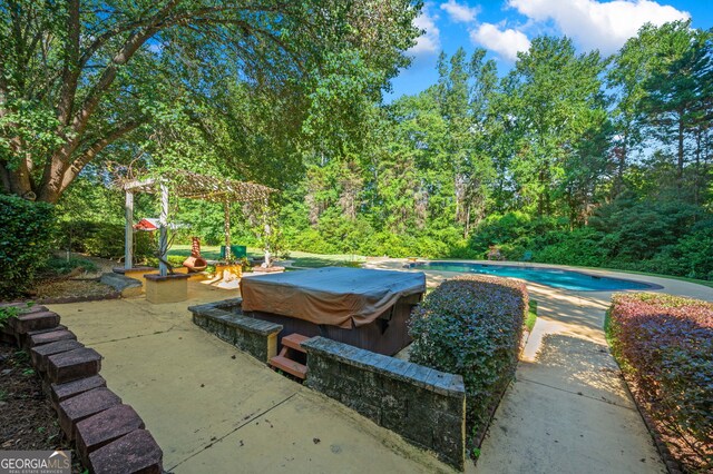 view of patio / terrace featuring a swimming pool with hot tub