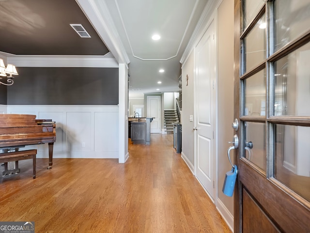 hall featuring crown molding and light hardwood / wood-style flooring