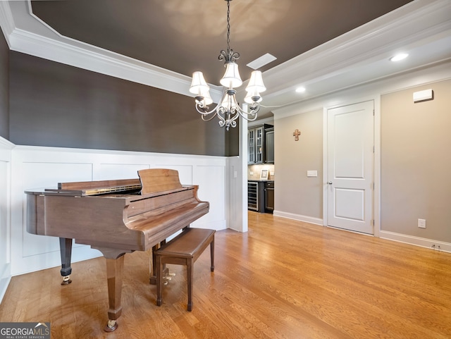 misc room featuring crown molding, an inviting chandelier, and light hardwood / wood-style floors