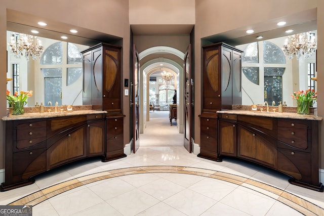 bathroom featuring tile flooring, a chandelier, and vanity